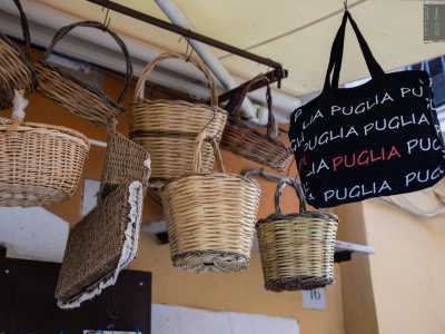 Anche qui spiccano le gerle appese al tendone, a cui fanno compagnia borse nere che riportano la dicitura �Puglia�...